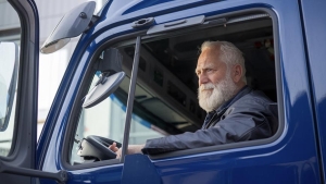 Conductor mayor conduciendo un camión