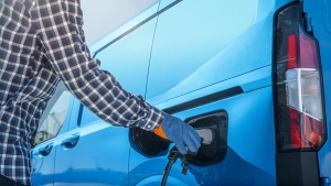 Conductor cargando una furgoneta eléctrica